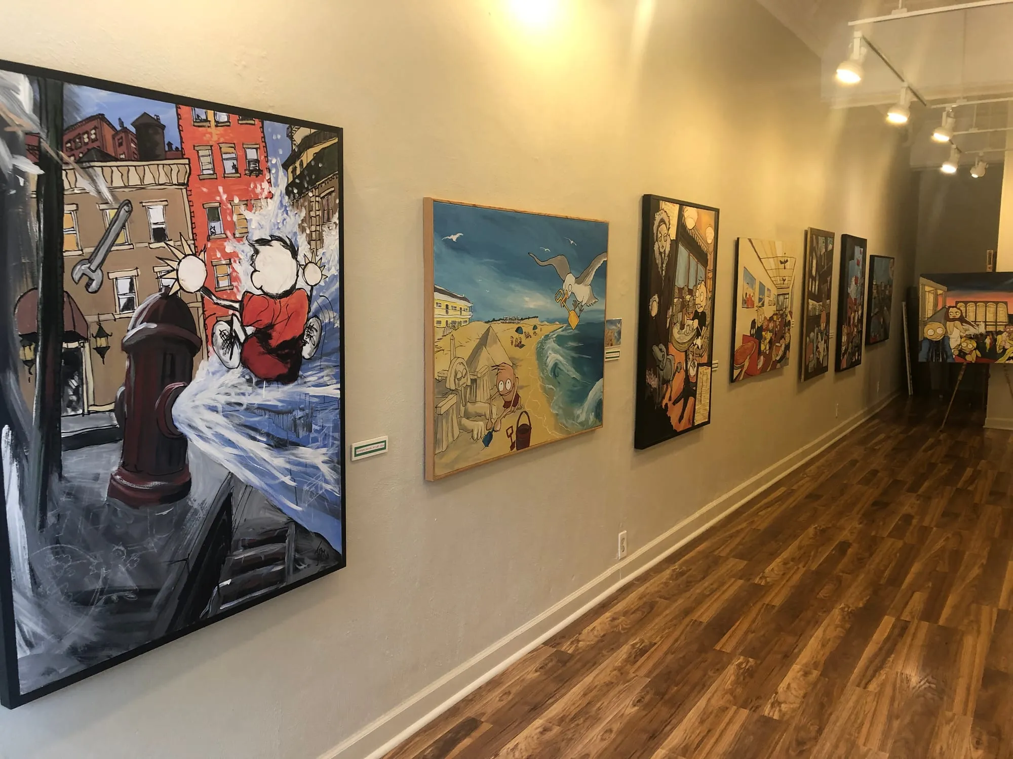 Paintings hung along the gallery